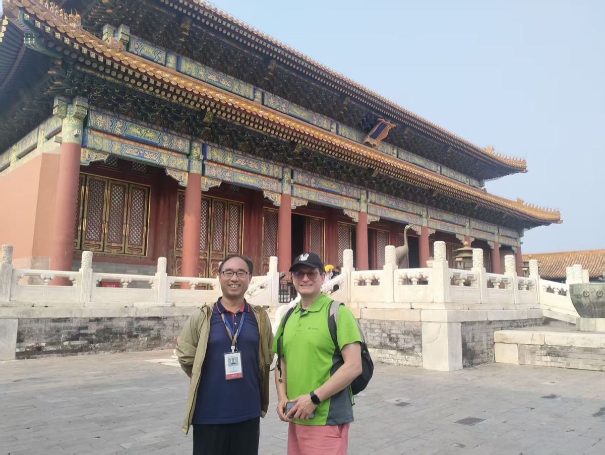 Our driver with a guest in front of a hall in the Forbidden City